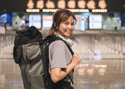 Reisende mit Rucksack beim Abflug zum Work and Travel
