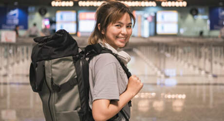 Reisende mit Rucksack beim Abflug zum Work and Travel