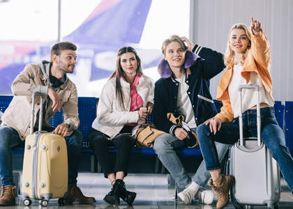 Junge Leute warten am Flughafen - Checkliste Gruppenreise